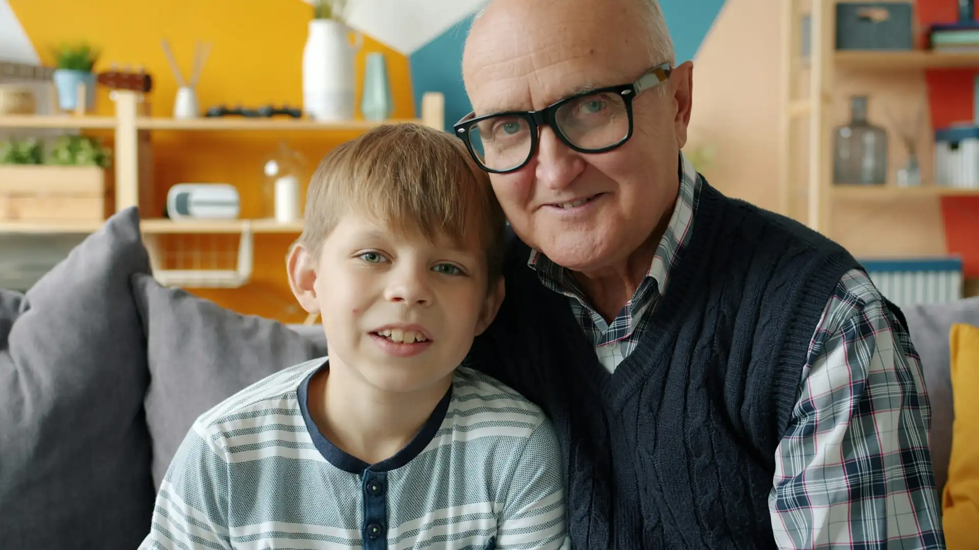 A grandfather and his grandson sitting on a sofa, seen with normal vision